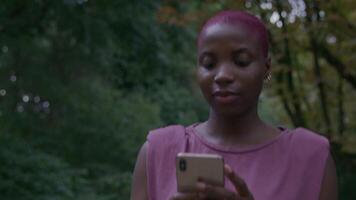 slow motion van jonge vrouw wandelen in park met behulp van telefoon video