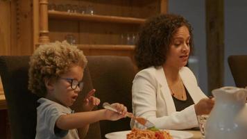 mor och son njuter av pasta vid middagen video