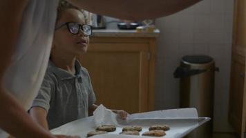 Mother and son putting homemade cookies in oven video