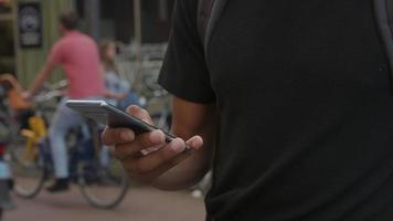 Zeitlupen-Neigung des jungen Mannes unter Verwendung des Smartphones, das Ohrstöpsel trägt video