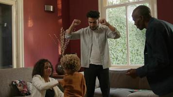 Cámara lenta de familia multiétnica bailando juntos en casa