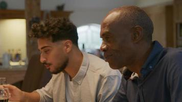 Two men sitting down at family dinner video