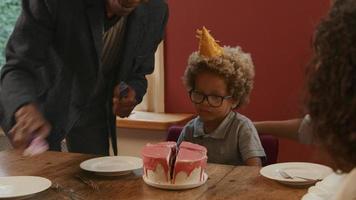 Grand-père coupe le gâteau d'anniversaire pour petit-fils video