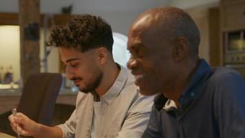 Two men sitting down at family dinner video