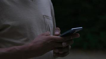 slow motion van jonge man SMS op mobiele telefoon