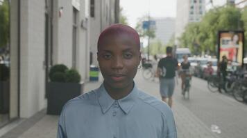 Slow motion of young woman with shaved hair walking on pavement video