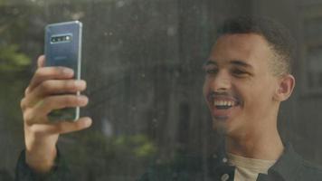 slow motion van vrolijke jonge man op smartphone video-oproep