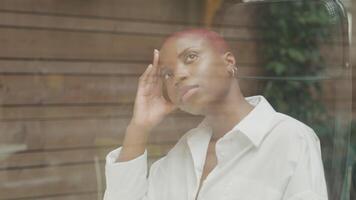 Young woman with shaved hair working by window video