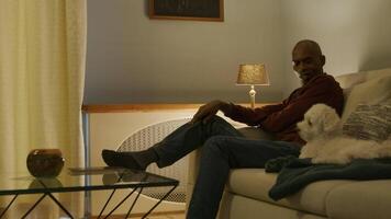 Mature man on sofa with pet dog video