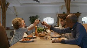 Family toasting with wine glasses at dinner video