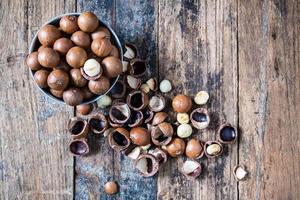 Nueces de macadamia con cáscara en un bol foto