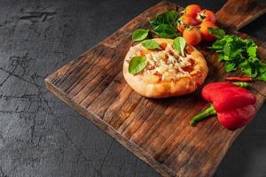 Pizza on wooden pizza board photo