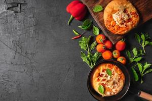 Pizzas in pan and on wooden tray photo