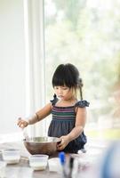 niña horneando en una cocina foto