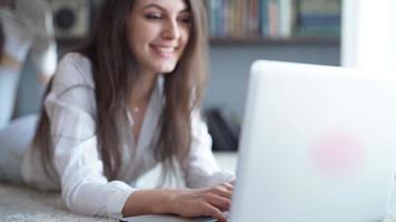 glad ung vacker kvinna som använder bärbara datorer, inomhus video