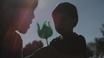 Slow motion of father and son playing with toy windmill video