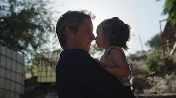 Slow motion of father holding daughter in sunlight video