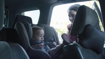 cámara lenta de madre poniendo a su hija en el asiento del coche video