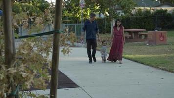 Slow motion of mother and father walking with daughter video