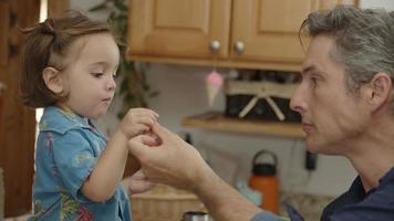 Slow motion of father giving daughter snack video