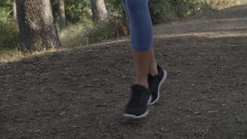Slow motion of young woman's feet running on track