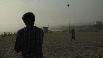 slow motion van mannen spelen met de bal op het strand video