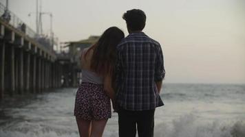 câmera lenta de um jovem casal olhando o mar