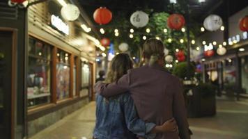 câmera lenta de um casal apaixonado caminhando em chinatown à noite video