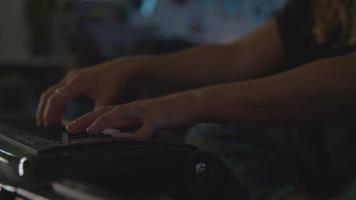 Slow motion of woman playing keyboard at night