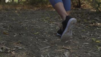 Slow motion of woman wearing training shoes walking on track video