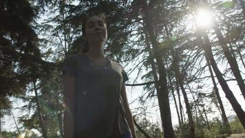 Zeitlupe der jungen Frau, die durch Wälder geht video