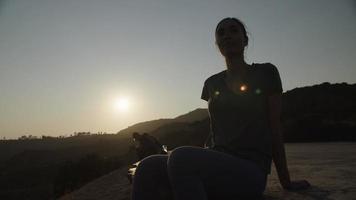 Slow motion of woman sitting at sunset video