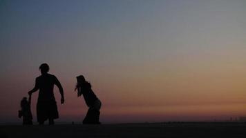 Zeitlupe der Familie am Strand bei Sonnenuntergang video