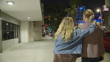 Slow motion of loving couple walking in city at night