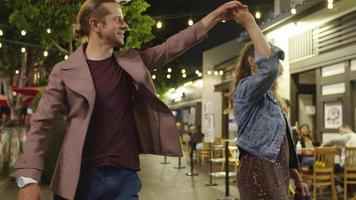 Zeitlupe von Mann und Frau, die nachts in der Stadt tanzen video