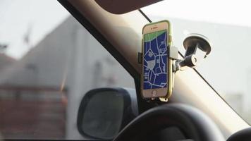 Slow motion of man using sat nav app on smartphone in car