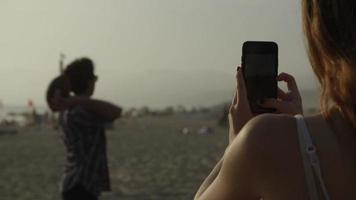 cámara lenta de mujer tomando fotos de hombre lanzando pelota video