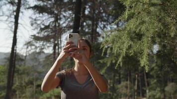 slow motion de femme prenant selfie sur téléphone en forêt video