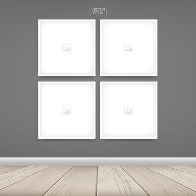 Four empty square photo frames on gray wall