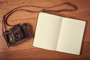 Vintage camera and  diary on wooden table. photo
