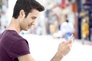 Young man writing message on mobile phone