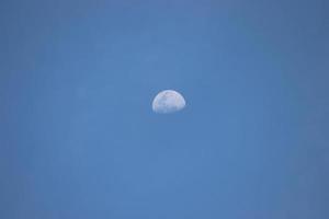 media luna en el cielo azul a la luz del día foto