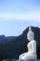 White buddha statue and blue sky background in Thailand.