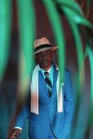 hombre dandy afroamericano en traje azul y sombrero de paja.