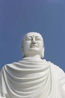 White Buddha statue on the background of bright blue sky