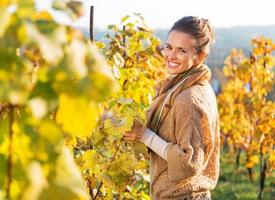 portrait of happy young woman in autumn vineyard