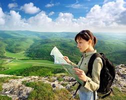 Woman looking at map while hiking photo