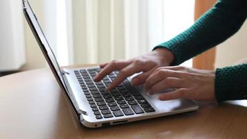 primo piano della mano della donna di affari che digita sulla tastiera del computer portatile. primo piano di una femmina mani impegnate a digitare su un laptop. video