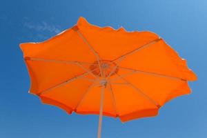 Orange parasol against a blue sky