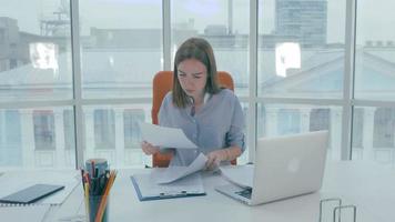 jovem empresária trabalhando em um laptop em um escritório moderno video